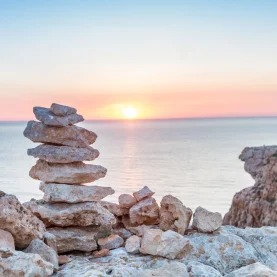 Smooth stones scattered across the beach, symbolizing groundedness and mindfulness in Thrive Therapy's integrative counselling.